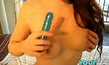 Vellystig brunhåret kvinde stikker en blå dildo op i sin fisse