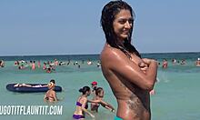 امرأة سمراء مفلس مع هيئة رهيبة هي مظاهرة لها تان على الشاطئ .
